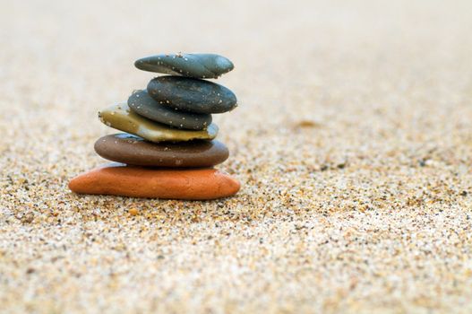 Stack of beach stones on sand. Harmony, life, balance concepts