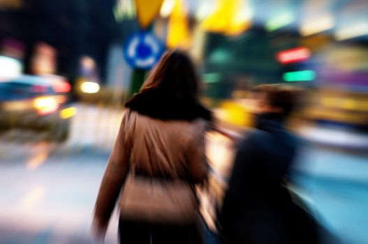 Two attractive women walking in a big city centre at night