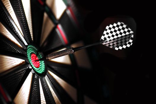 One arrow in the centre of a dart board. Shallow depth of field