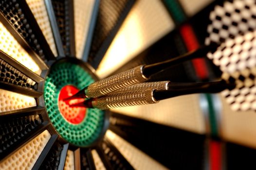 Three arrows in the centre of a dart board. Shallow depth of field