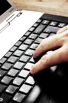 Hands typing on a laptop in home