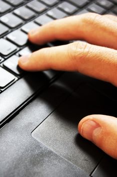 Hands typing on a laptop in home