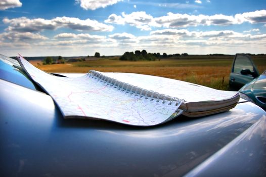 Map on car mask, on second plan summer holidays scenery