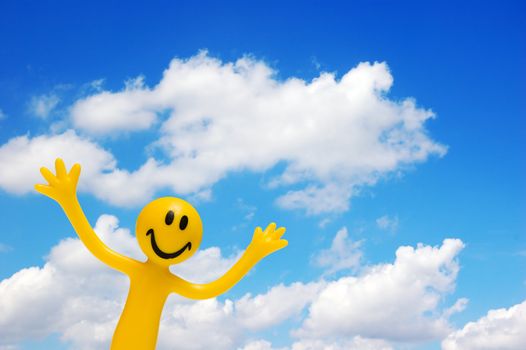 A happy face with arms raised on blue sky. Conceptual