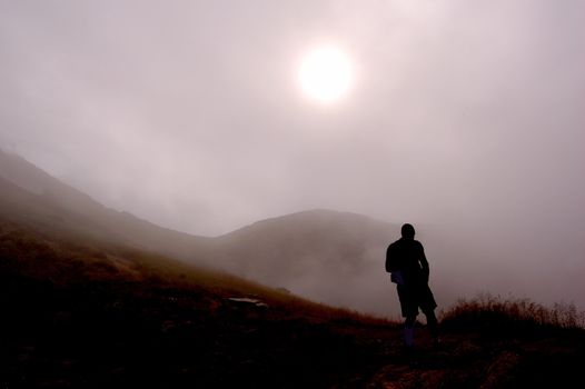 Man looking at foggy mountains scenery
