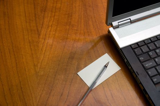 Modern business desk with laptop pen and business card