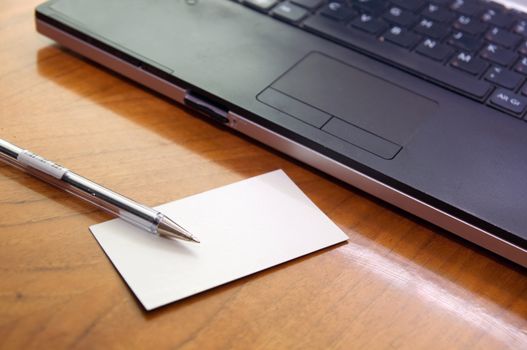 Modern business desk with laptop pen and business card