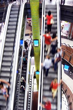 Shopping abstract. People rush on escalator motion blurred