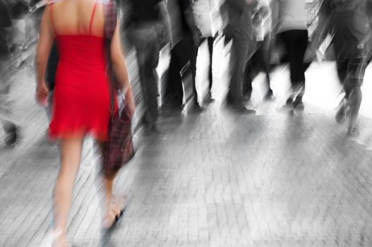 Busy big city street. Woman in red among black and white