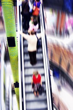 Shopping abstract. People rush on escalator motion blurred