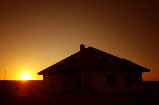 Sunset silhouette of house with free space above