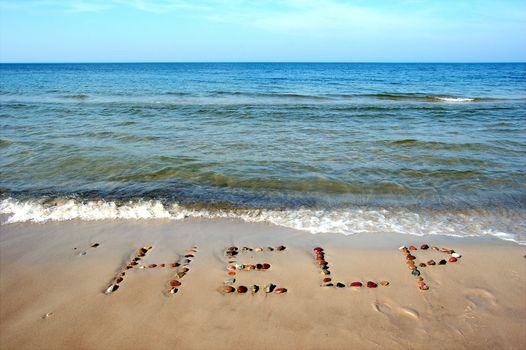 Word HELP on beach sand, made from rocks