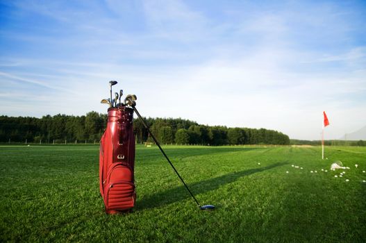 Golf gear on the golf field. Red flag in the background