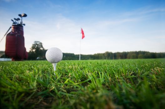 Golf gear on the golf field. Red flag in the background