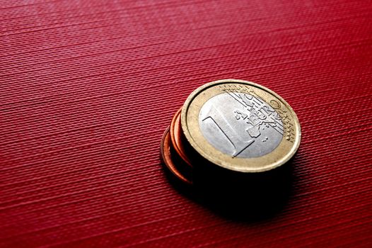 Euro coins on red surface