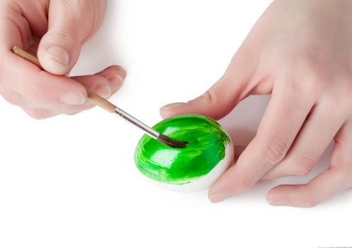 Woman decorating white egg with paint