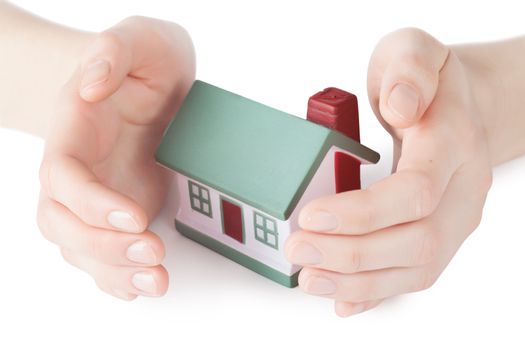 Little house toy covered by hands isolated over white background