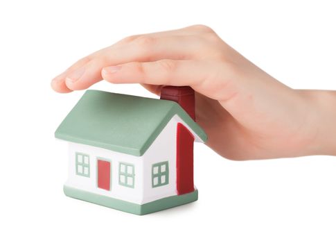 Little house toy covered by hand isolated over white background