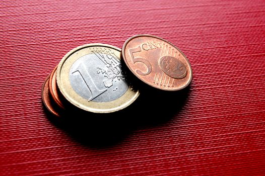 Euro coins on red surface