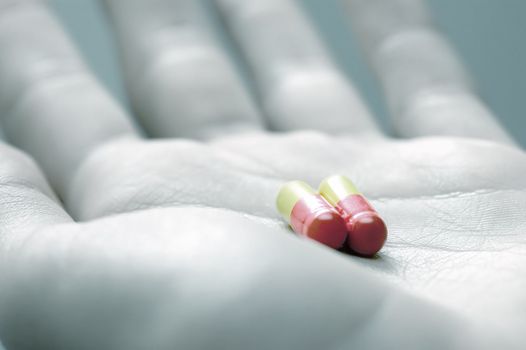 Taking pills. Hand with two capsules