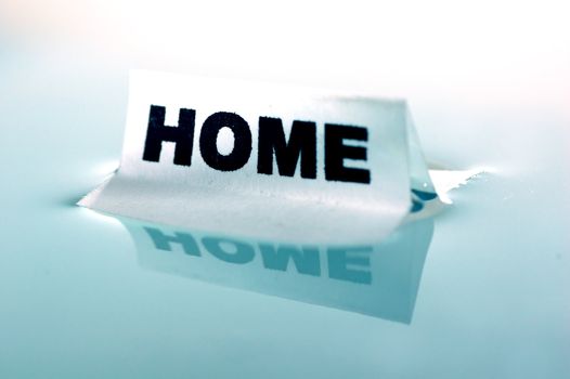 Card floating on water surface with printed word: HOME