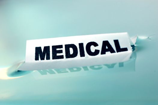 Card floating on water surface with printed word: MEDICAL