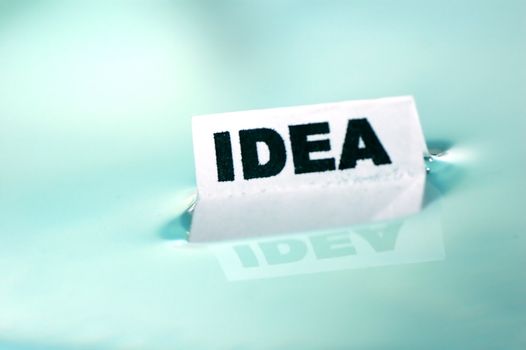 Card floating on water surface with printed word: IDEA