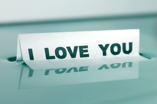 Card floating on water surface with printed word: I LOVE YOU