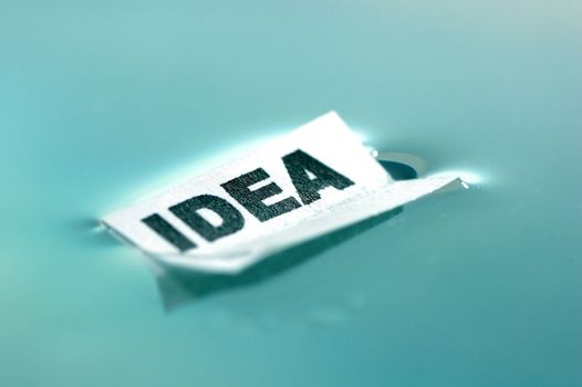 Card floating on water surface with printed word: IDEA