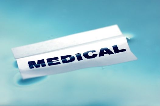Card floating on water surface with printed word: MEDICAL