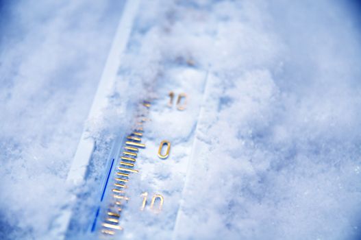 Below zero. Thermometer in snow indicating minus temperature. Cold winter concept.