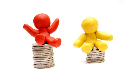 Plasticine figures sitting on coins piles. Winner and loser in business