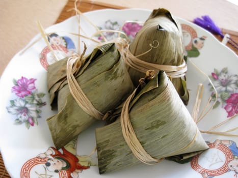 3 pyramid-shaped mass of glutinous rice wrapped in leaves, one culture occasion in Chinese