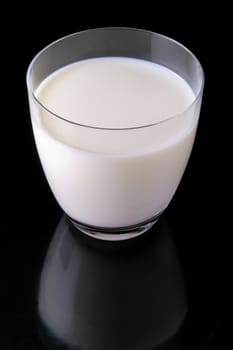Glass of milk isolated in black background