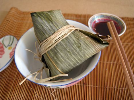 serving a food of glutinous rice wrapped in leaves for special occasion