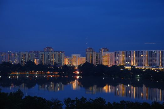 Singapore housing aprtment buidings are nicely reflected in a calm water. Blue colour added the beauty