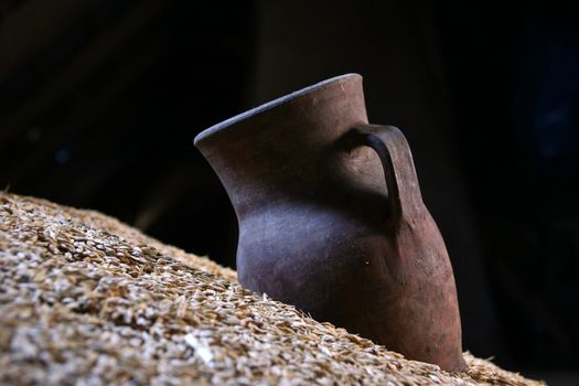 On a heap of grain the old jug lies