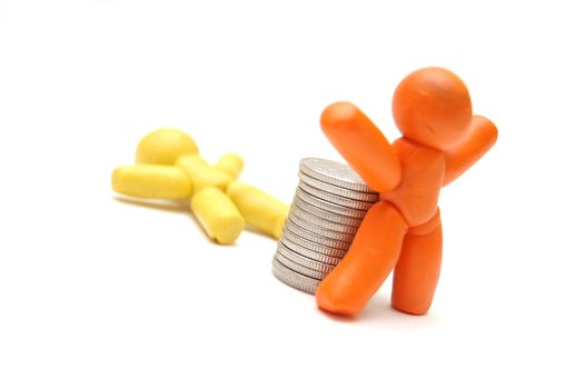 2 plasticine figures, one staying in front of coins pile. Competition in business