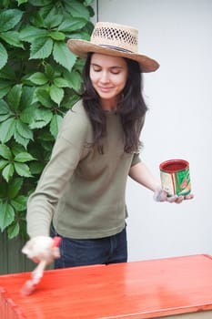Beautiful girl colours the wooden surface