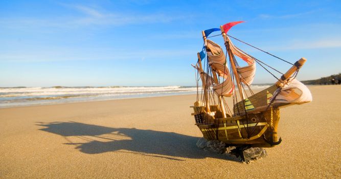 Ship model on summer sunny beach. Travel, voyage, vacation concepts