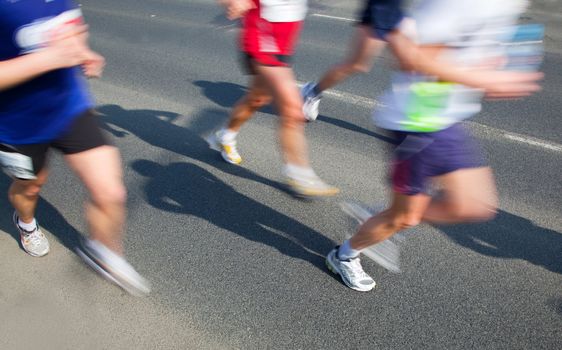 Running fast in marathon, legs close up. Sport, competition, energy.