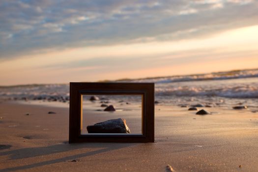Frame on the beach at sunset. Conceptual, memories from holidays.