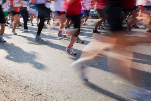 Running fast in marathon, legs close up. Sport, competition, energy.