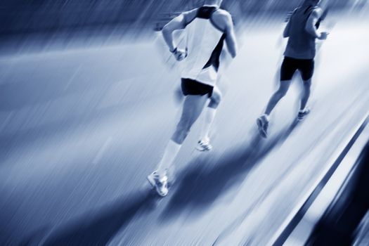 Two runners moving fast. Workout, sport, exercise. Motion blur