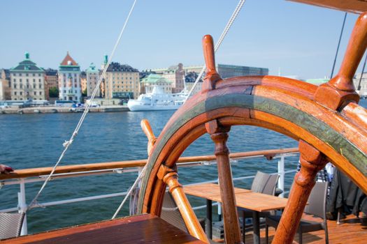 An old, wooden ship helm and a view on Stockholm, Sweden