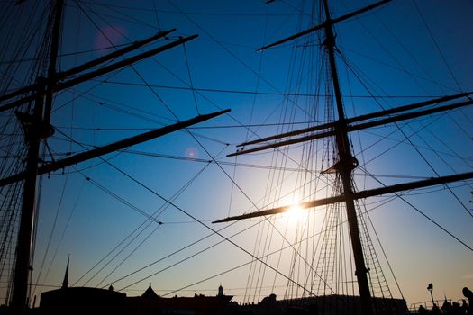 Ship sails silhouette on sunset background