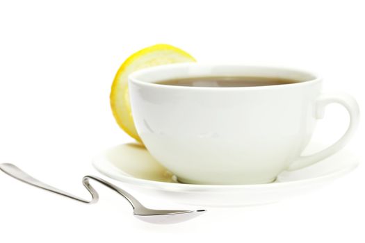 white cup, a spoon and a lemon  isolated on white