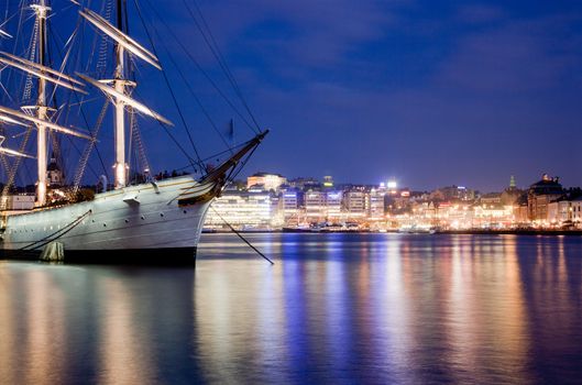 Ship at night in Stockholm, Sweden. City reflections in water