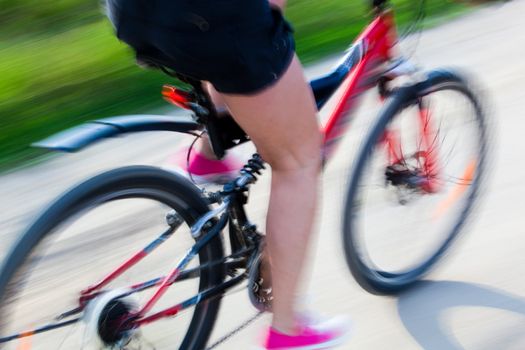 Active woman on a bike trip during summer. Lens blur