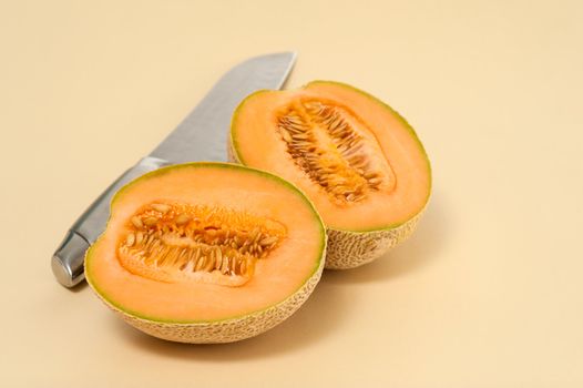 Cantaloupe cut in half on a neutral background.